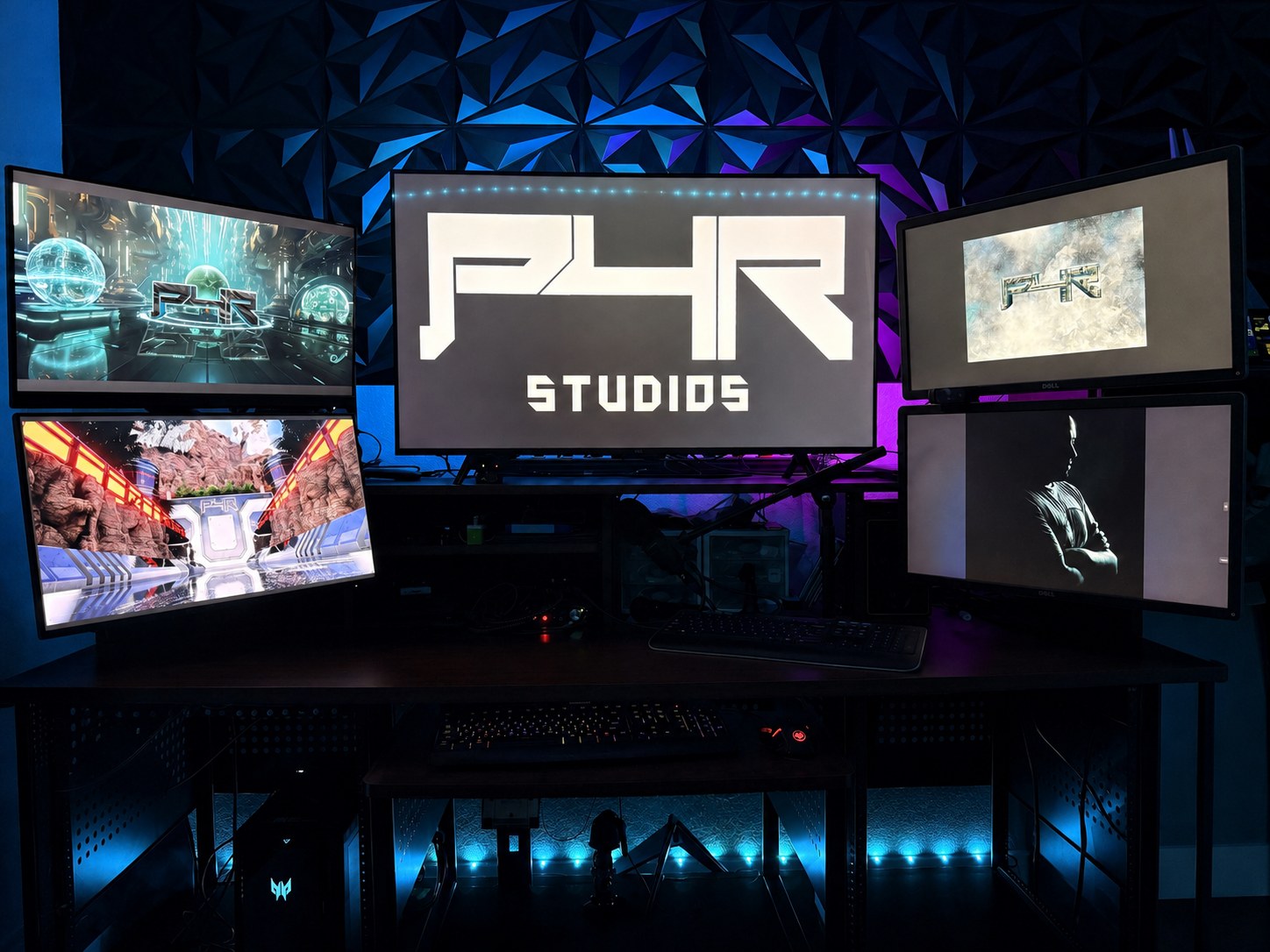 The P4R Studios desk: five monitors showing the P4R logo and artwork in front of RGB-lit acoustic wall panels